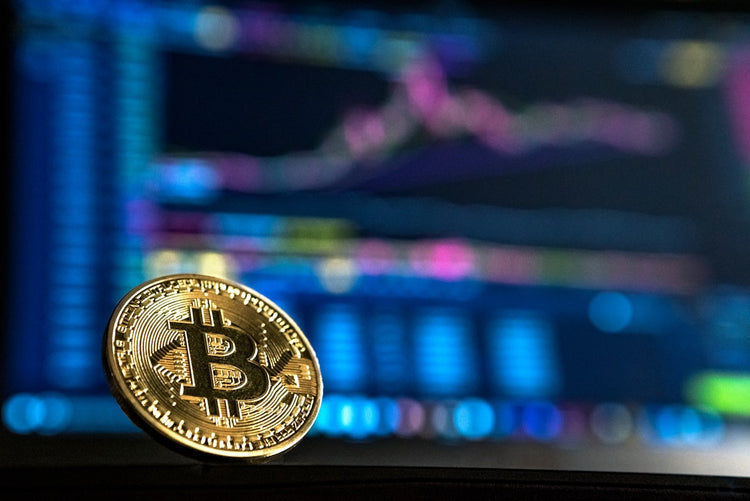 Bitcoin coin on a dark background with price chart